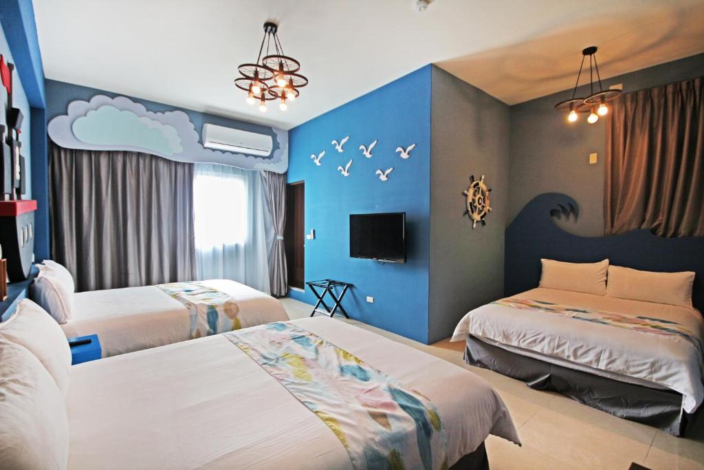台東市的住宿－Fun Trip - 小古堡與奧斯卡民宿，一间卧室设有两张床和蓝色的墙壁