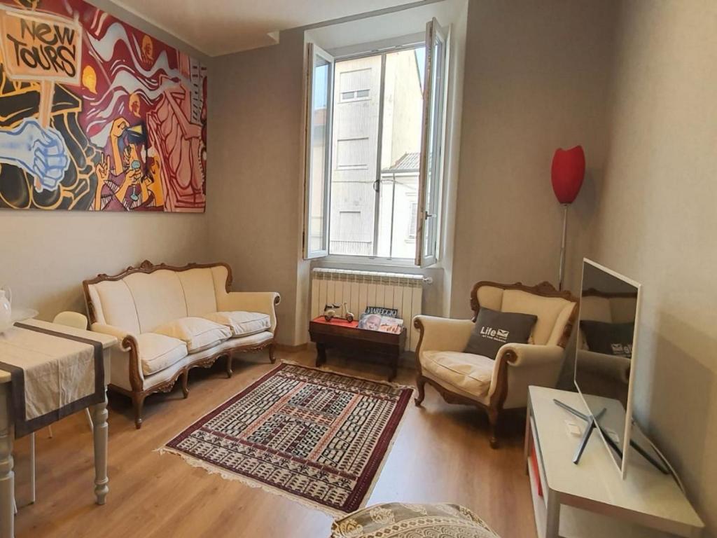 a living room with a couch and chairs and a window at Foscolo 27 a 100 m dal mare in Viareggio
