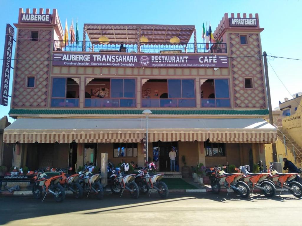 a group of motorcycles parked in front of a building at Hotel Trans Sahara Merzouga in Merzouga
