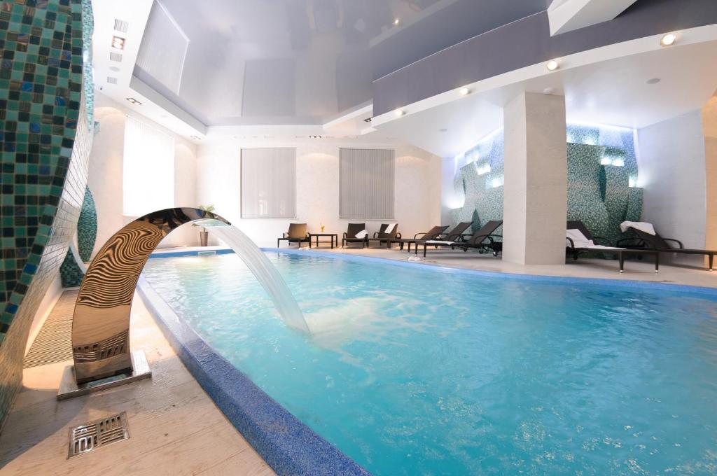 a swimming pool with a pool table and a tub at Taurus Hotel & SPA in Lviv