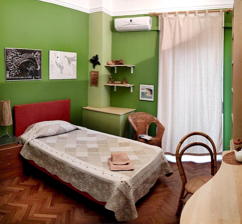 ein Schlafzimmer mit einem Bett und einer grünen Wand in der Unterkunft B&B VELARDI in Viagrande