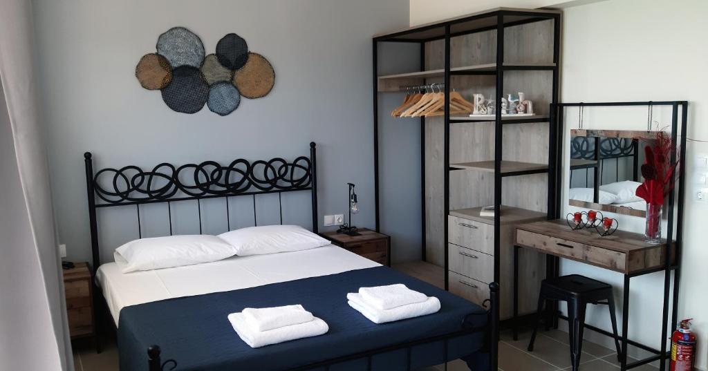 1 dormitorio con cama, mesa y espejo en Budget Studio 1 - Sea view - Renovated February 2021, en Charaki
