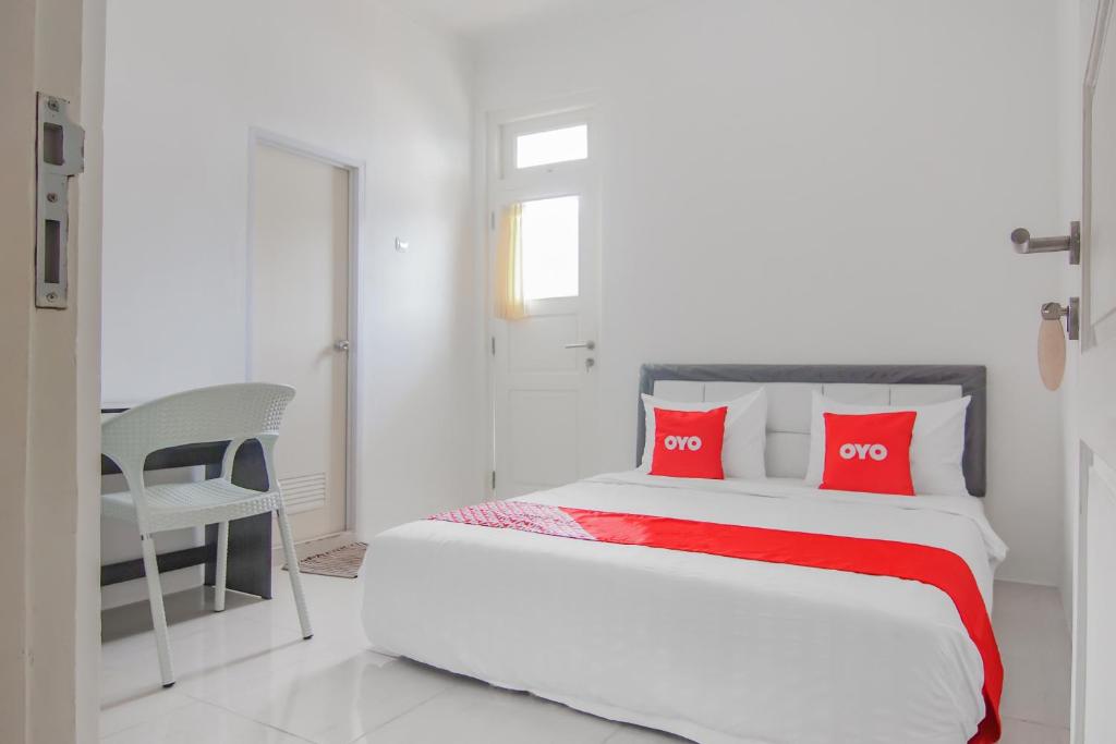 una camera con un letto con due cuscini rossi di Capital O 90342 Kemang Garden a Giacarta