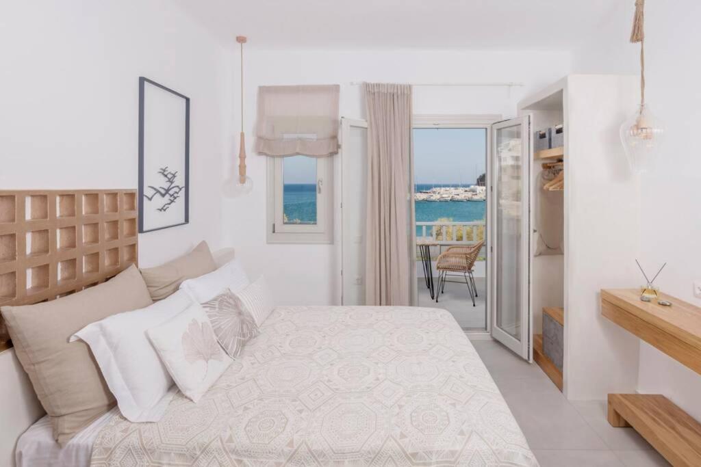 a bedroom with a bed and a view of the ocean at Vivere InBlue - Deluxe apartment over the sea in Pera Gyalos
