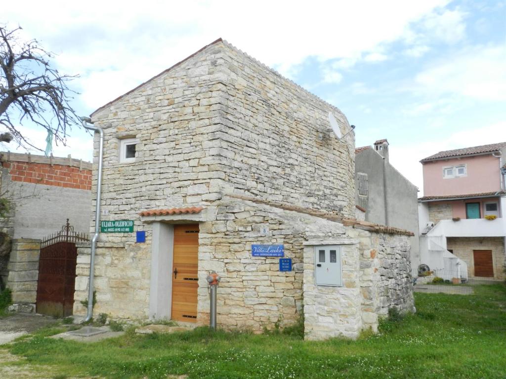 - un vieux bâtiment en pierre avec une porte en bois dans l'établissement Apartment Pokrajac, à Rovinjsko Selo