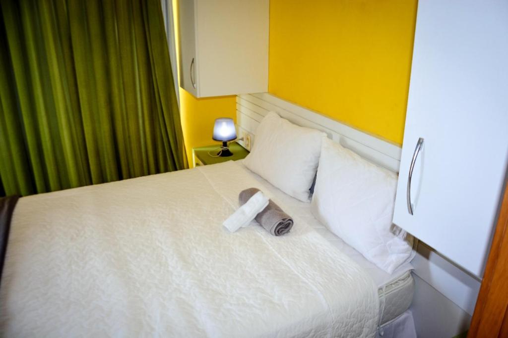 una habitación de hotel con una cama con un libro encima en Residence Victoria Brasil, en Natal