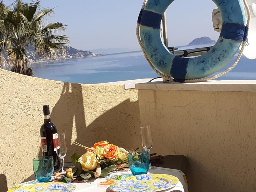 a table with a bottle of wine and a mirror at Alba Apartment in Laigueglia