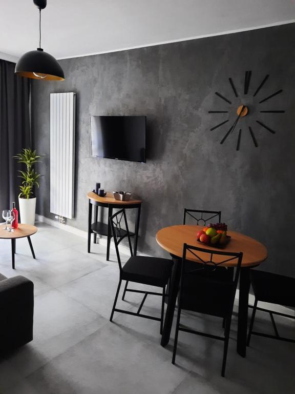ein Esszimmer mit einem Tisch und einer Uhr an der Wand in der Unterkunft Kryształ A10, Garaż in Karpacz
