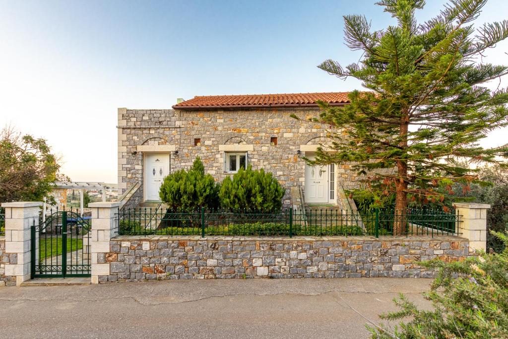 uma casa de pedra com uma cerca e uma árvore em Vista Loca em Lévktron