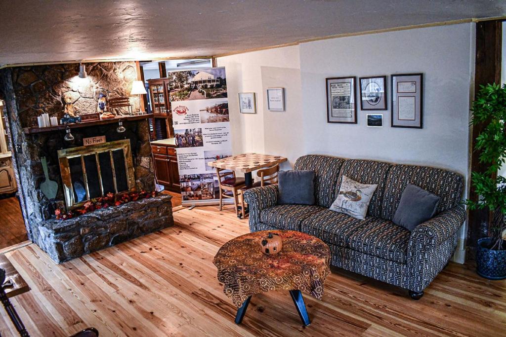 a living room with a couch and a fireplace at Brook Road Inn in Goshen