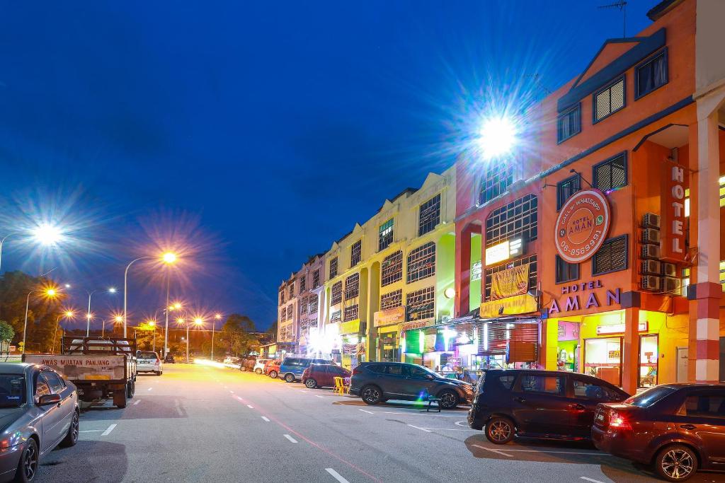 uma rua da cidade à noite com carros estacionados em Hotel Aman- Nilai & KLIA em Nilai