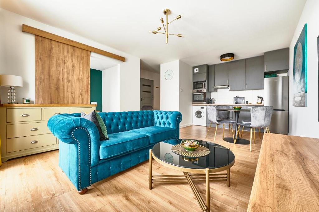 uma sala de estar com um sofá azul e uma mesa em Apartament Księżycowy em Olsztyn