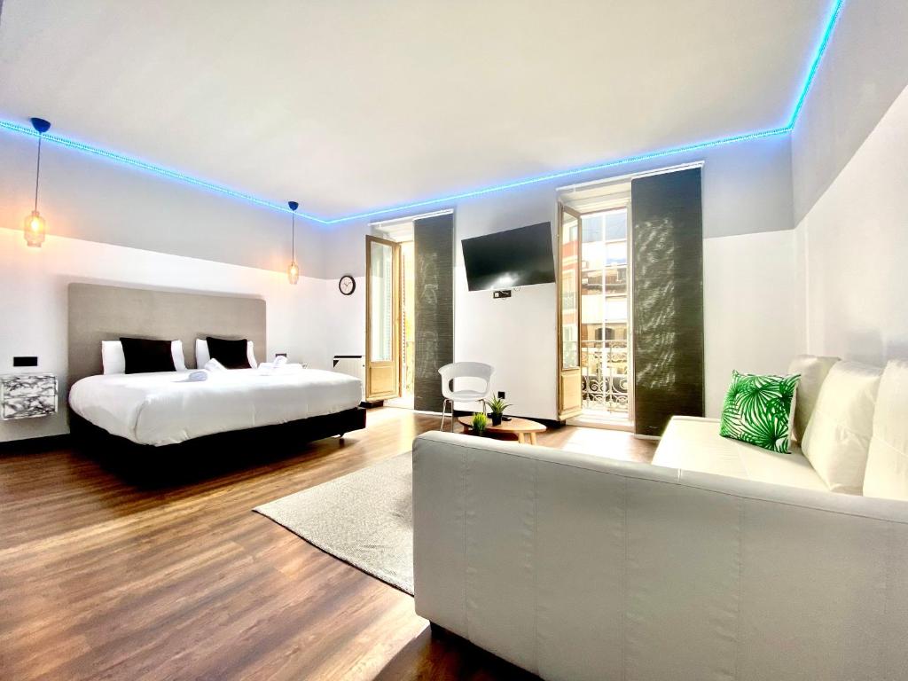 Habitación de hotel con cama y sofá en Royal Suites Madrid, en Madrid