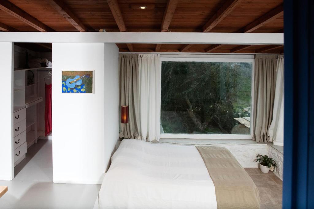 a bedroom with a bed and a large window at Lilly's Home -2 Bedrooms in Mýkonos City