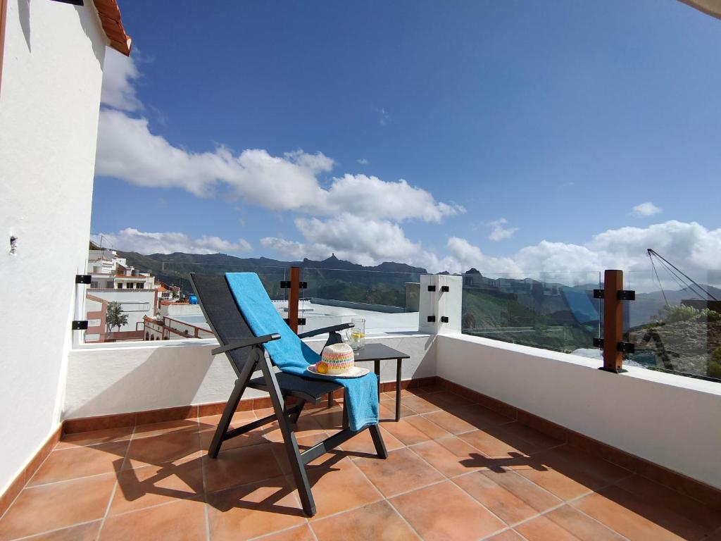 una silla azul sentada en un balcón con vistas en La Morada, en Artenara