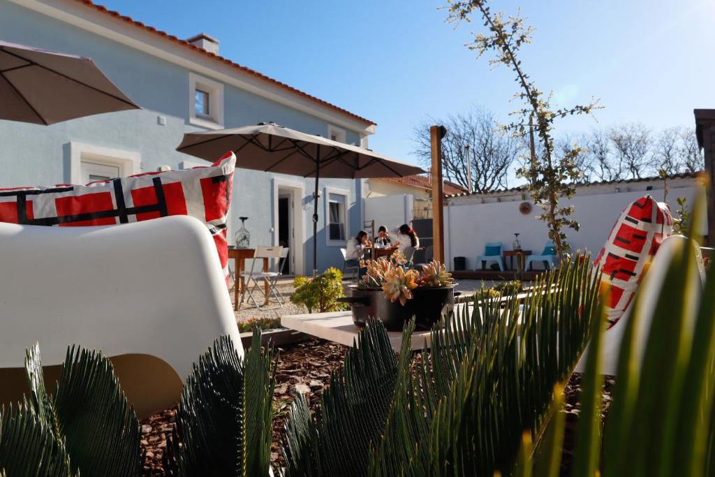 un grupo de personas sentadas bajo un paraguas en un patio en Casotas, en Lisboa