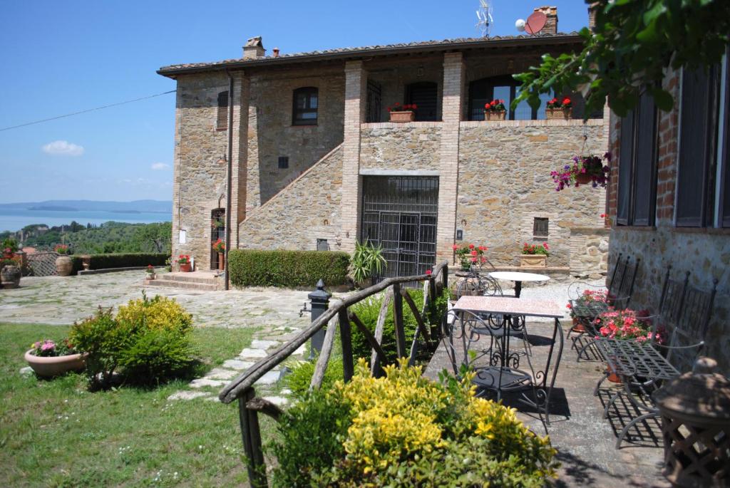 聖費利西亞諾的住宿－Casale sul Lago Trasimeno，石头房子前面有桌子