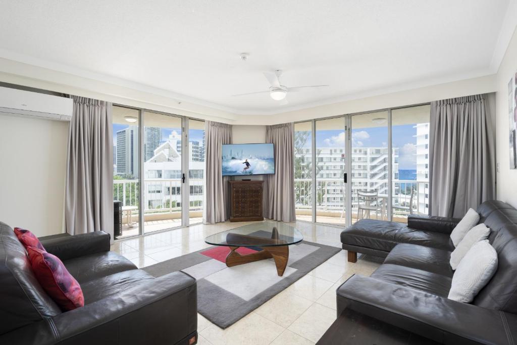 a living room with couches and a flat screen tv at Moroccan Resort - HR Surfers Paradise in Gold Coast