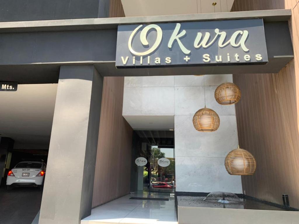 a restaurant with a sign on the front of a building at Motel Okura Villas y Suites in Guadalajara