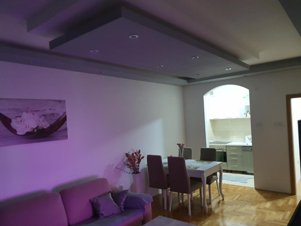 sala de estar con sofá púrpura y mesa en Oasis of Peace, en Trebinje