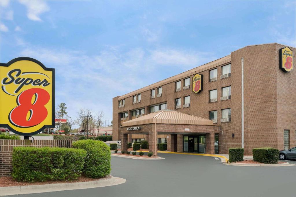 a hotel with a sign in front of it at Super 8 by Wyndham Raleigh North East in Raleigh