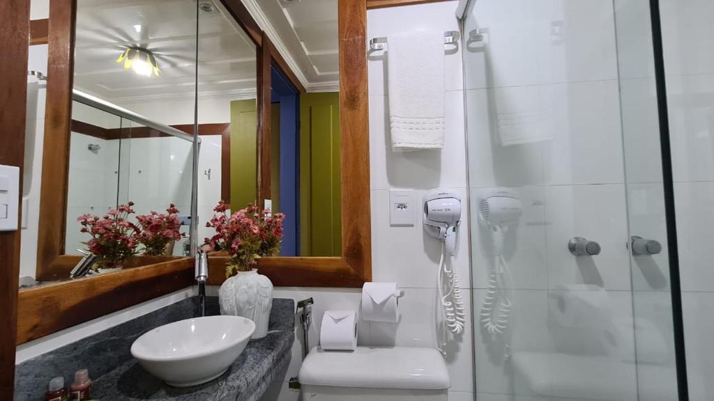 a bathroom with a sink and a glass shower at Hotel Pousada Casa Grande in Ouro Preto