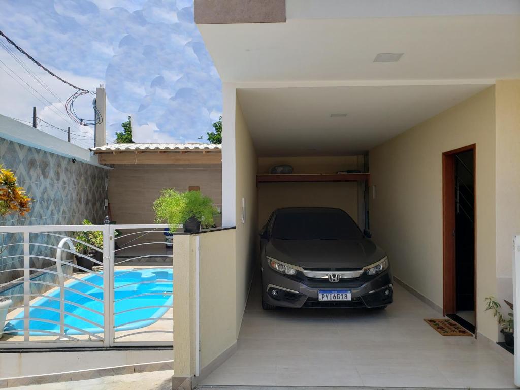 um carro estacionado numa garagem ao lado de uma piscina em Casa Duplex Iriri - Banheira e Piscina em Iriri