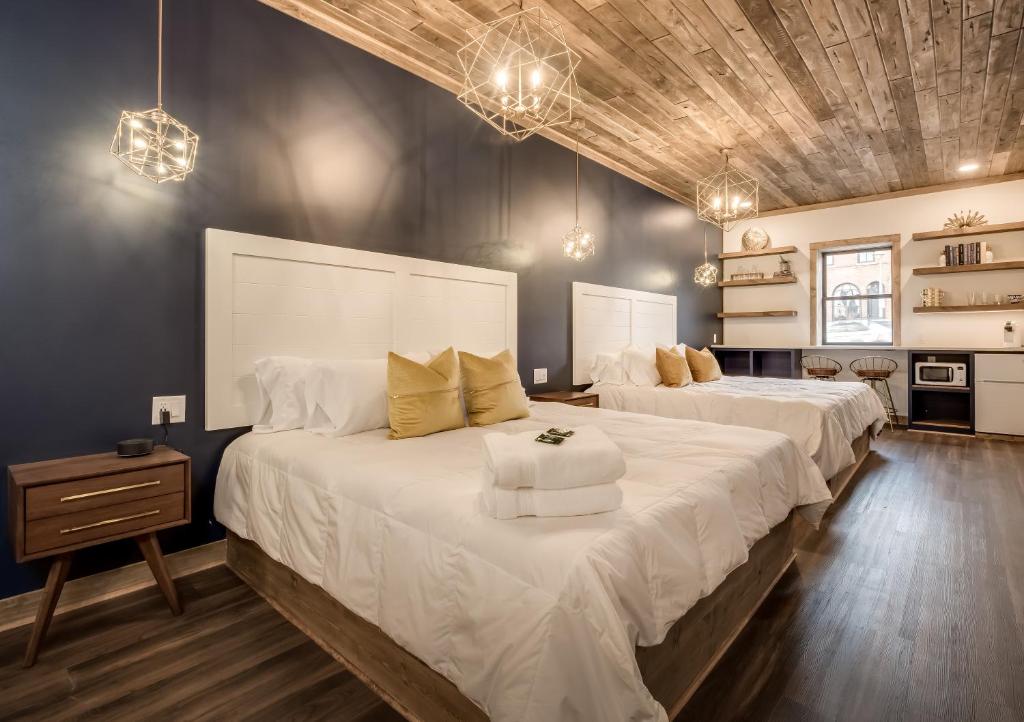 a bedroom with two beds with white sheets at The Port of Prescott Boutique Hotel in Prescott