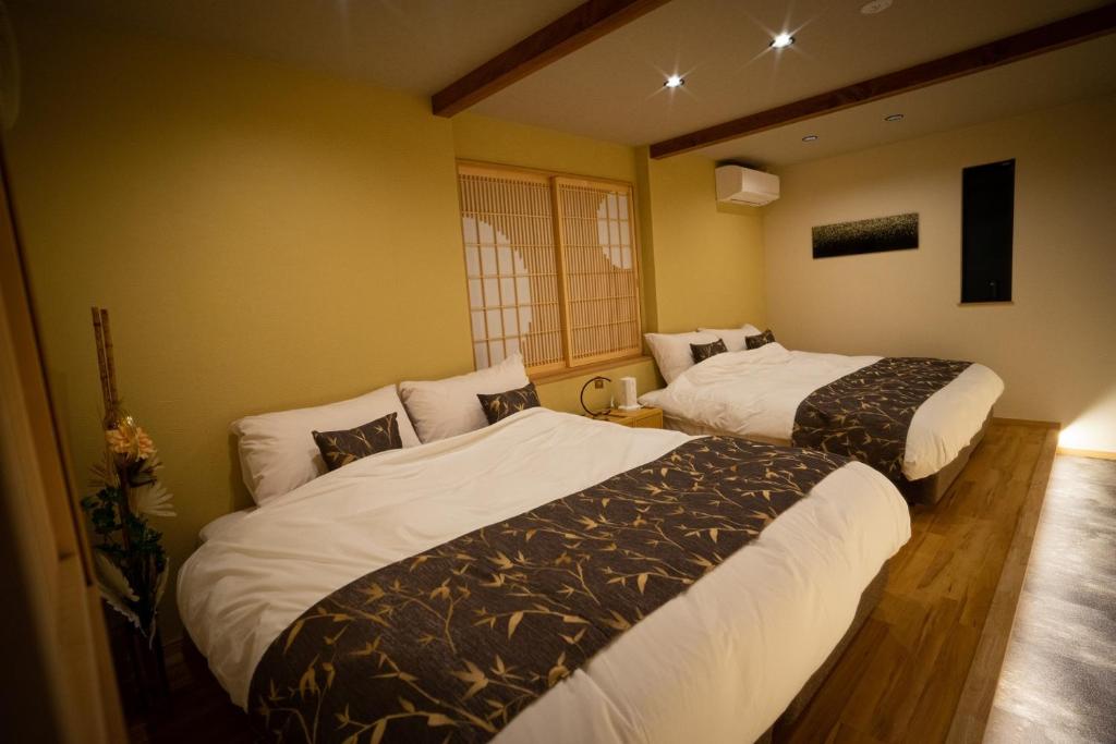名古屋市にあるIxyz別邸 月夜見の宿のベッド2台が備わる部屋