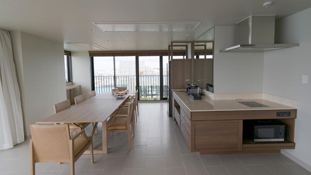 a kitchen with a long table and a dining room at MB GALLERY CHATAN by THE TERRACE HOTELS in Chatan