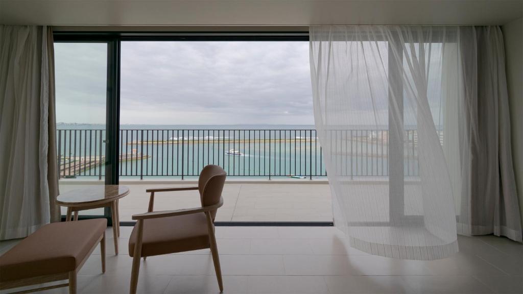 a room with a large window with a view of the ocean at MB GALLERY CHATAN by THE TERRACE HOTELS in Chatan