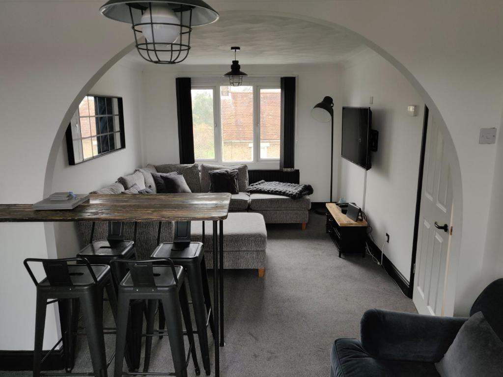 a living room with a table and a couch at Riverside Park Penthouse Apartment In St Neots in Saint Neots