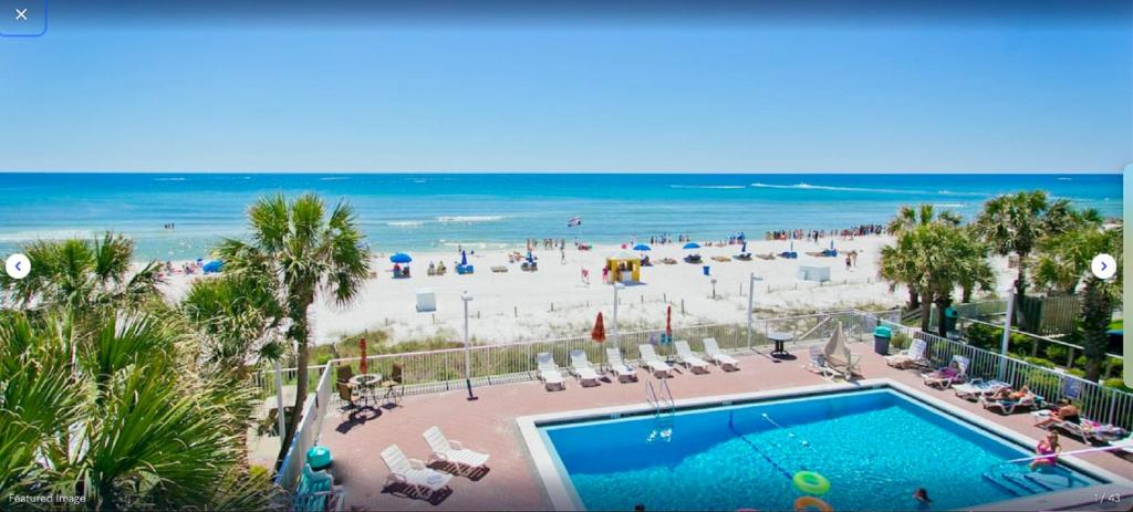 パナマ・シティ・ビーチにあるBikini Beach Resortのスイミングプールと海のあるビーチの景色を望めます。