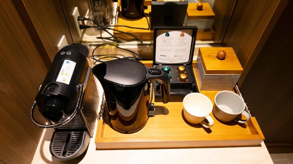 a table with a coffee maker and cups on it at MB GALLERY CHATAN by THE TERRACE HOTELS in Chatan