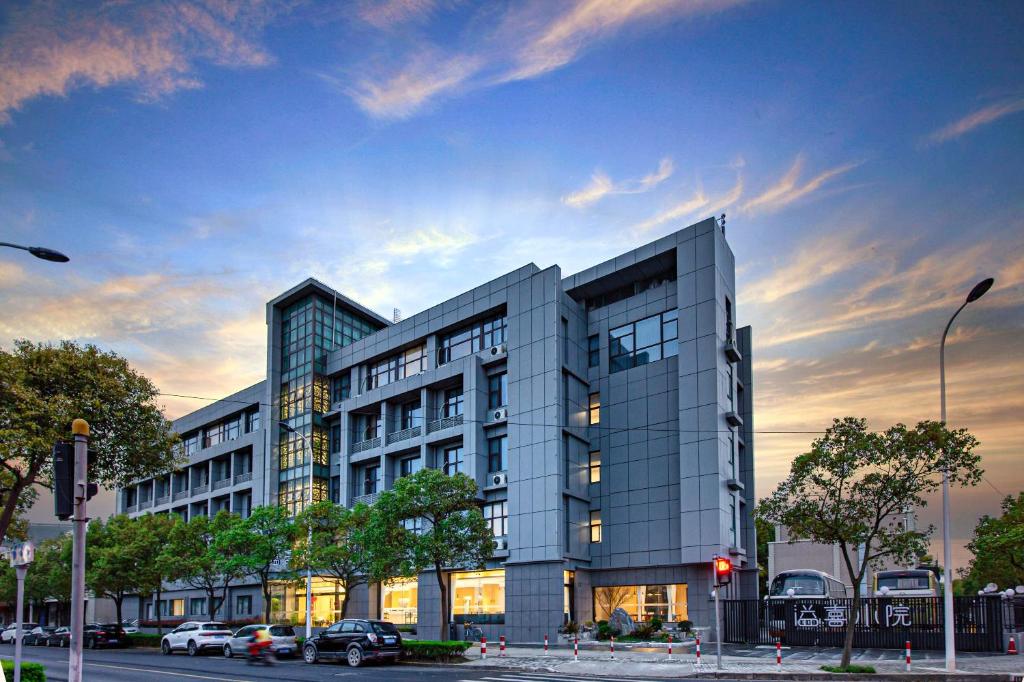 a large building on a city street with a sky at Shanghai JOYFUL YARD Hotel-Free shuttle bus from Pudong Airport and Disneylan in Shanghai