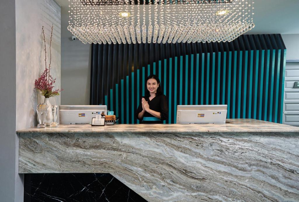A polished reception desk beneath a large decorative chandelier.