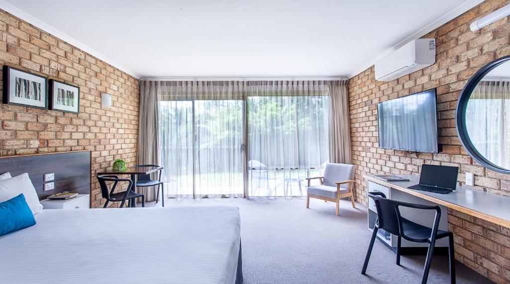 a living room filled with furniture and a large window at Sunshine Coast Motor Lodge in Woombye
