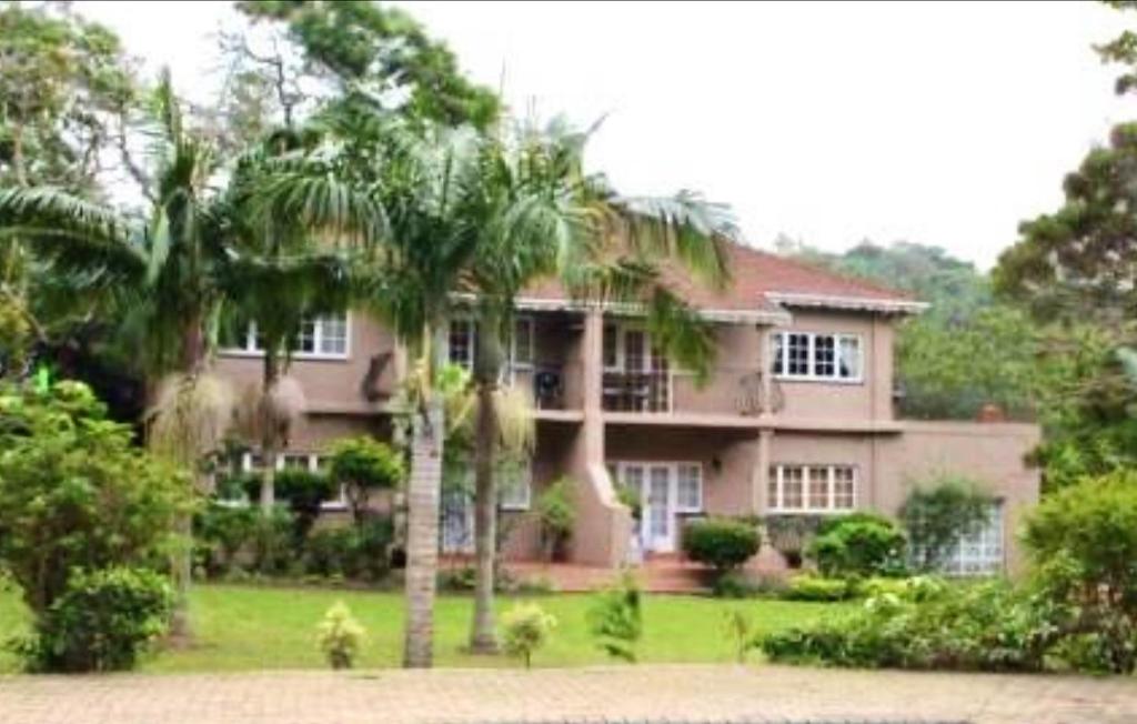 a large pink house with palm trees in front of it at The Courthouse in Ramsgate