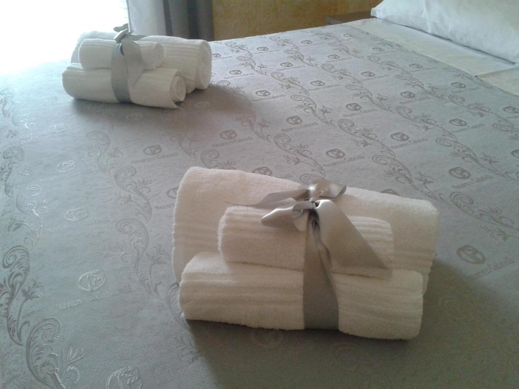 2 asciugamani pieghevoli sono seduti su un letto di B&B Casa Venezia a Bernalda