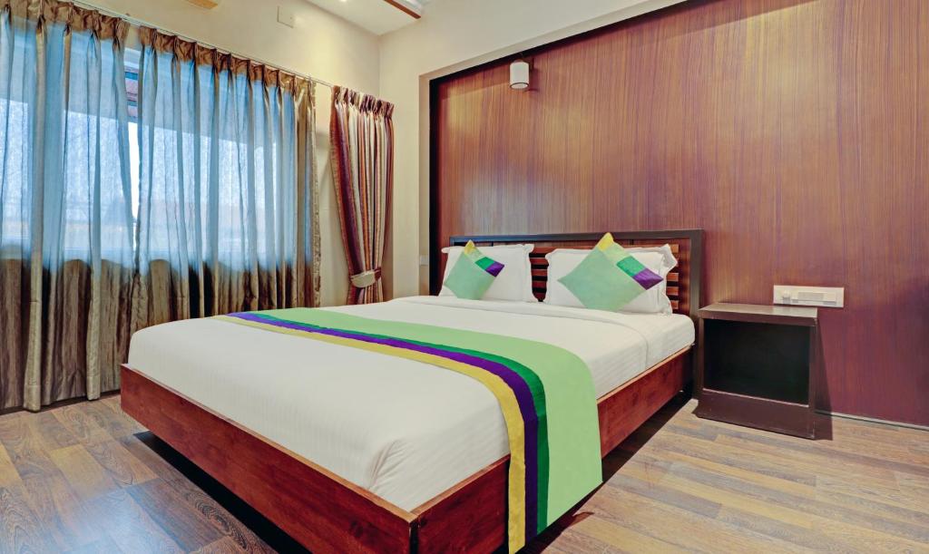 バンガロールにあるTreebo Trend Astor HSR Layoutのベッドルーム(大型ベッド1台、大きな窓付)
