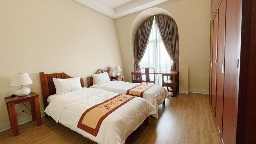 pokój hotelowy z 2 łóżkami i oknem w obiekcie Pacific Place Serviced Apartment w mieście Hanoi