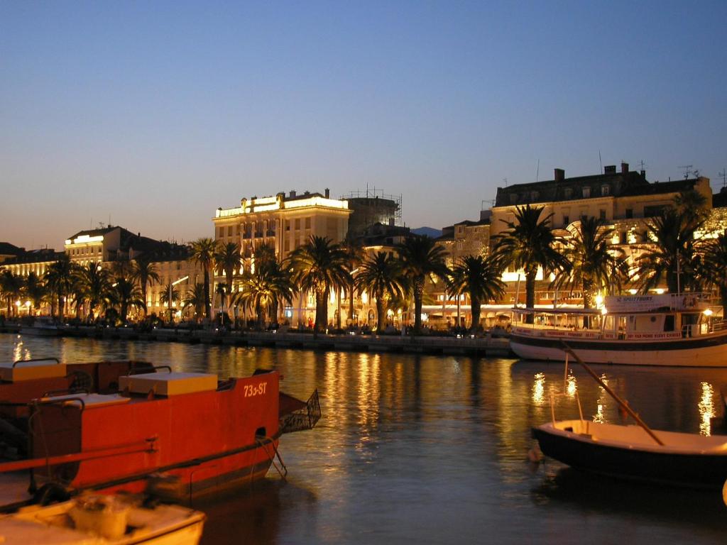 a group of boats in a river with buildings and palm trees at Apartment Martea in Split