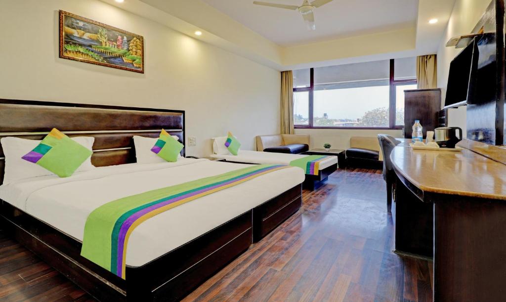 a hotel room with two beds and a desk at Itsy By Treebo - Southend in Chandīgarh