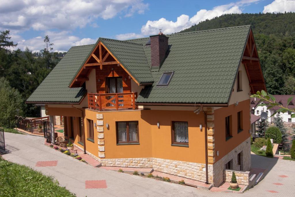 uma casa com um telhado verde em Willa Marie em Krynica Zdrój