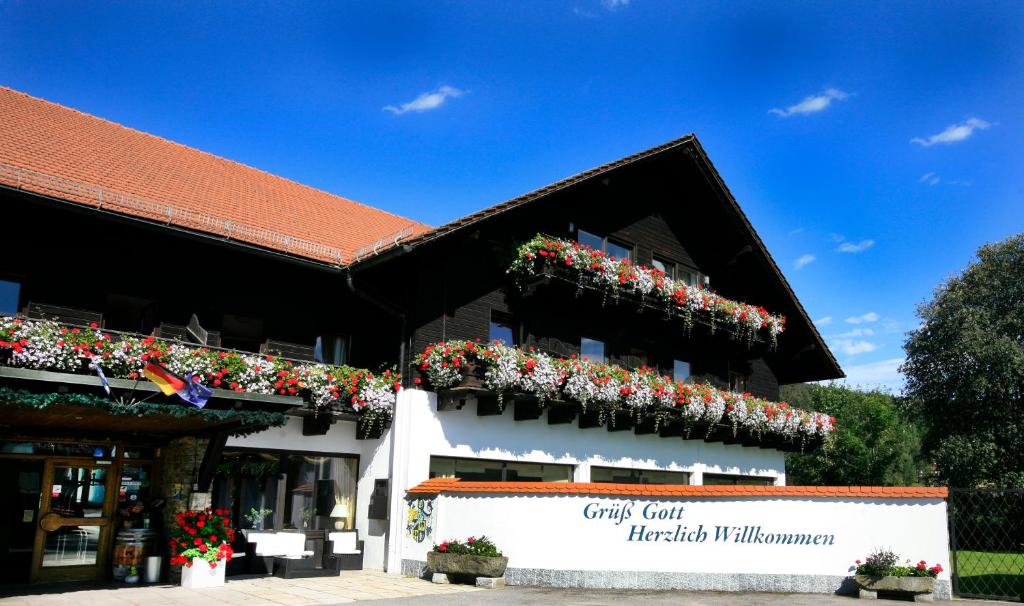 a building with flowers on the side of it at Hotel Gut Schmelmerhof in Sankt Englmar