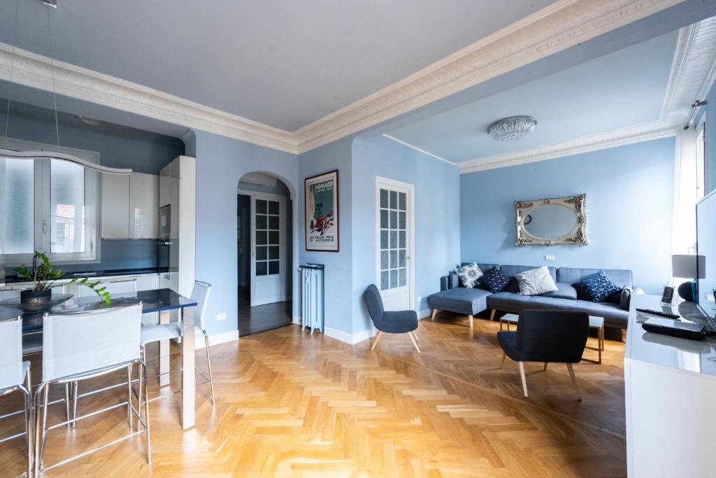 una cucina e un soggiorno con pareti blu e pavimenti in legno di Londres a Nizza