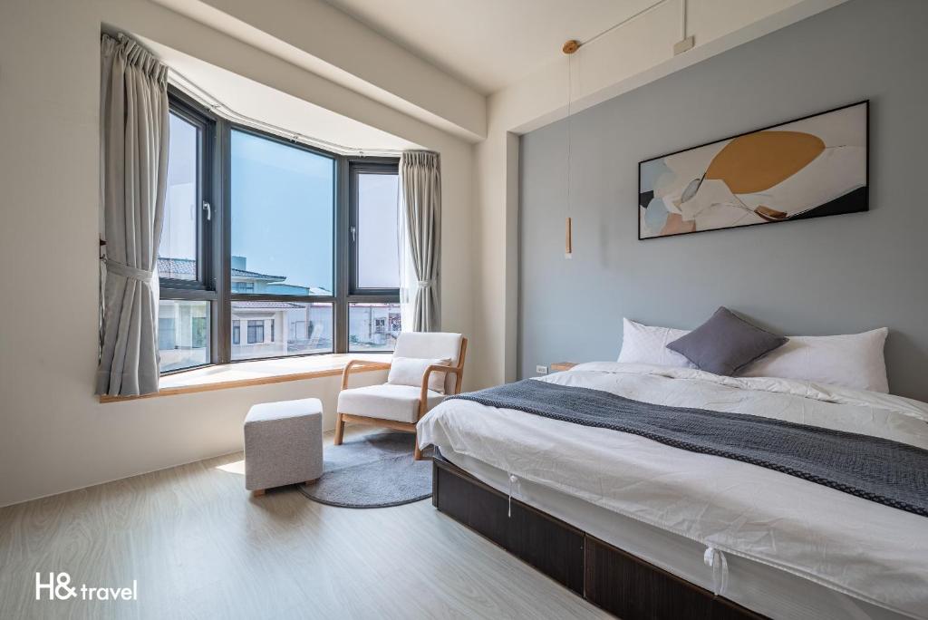 1 dormitorio con 1 cama, 1 silla y ventanas en H& Taitung Feng Lin Resort Hotel en Taitung