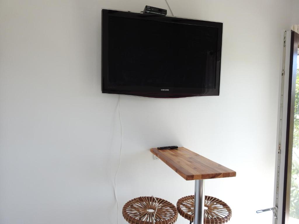 a flat screen tv hanging on a wall with a wooden table at Pokoj dwuosobowy hotelowy in Łeba