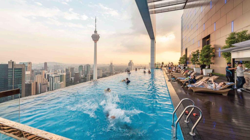 a pool on top of a building with people in it at The Platinum KLCC by iRent365 in Kuala Lumpur