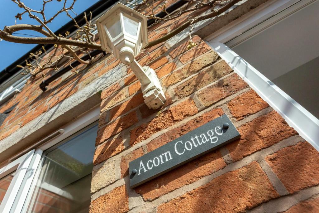 a street sign on the side of a brick building at Acorn Cottage in Loughborough